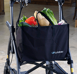 An UPWalker-branded walker tote bag full of fresh groceries and connected behind the seat of an upright walker.